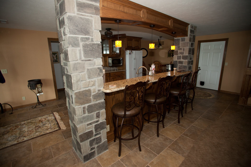 Foto di una cucina tradizionale di medie dimensioni con pavimento con piastrelle in ceramica, pavimento marrone, ante di vetro, ante in legno bruno, top in granito, elettrodomestici bianchi e nessuna isola
