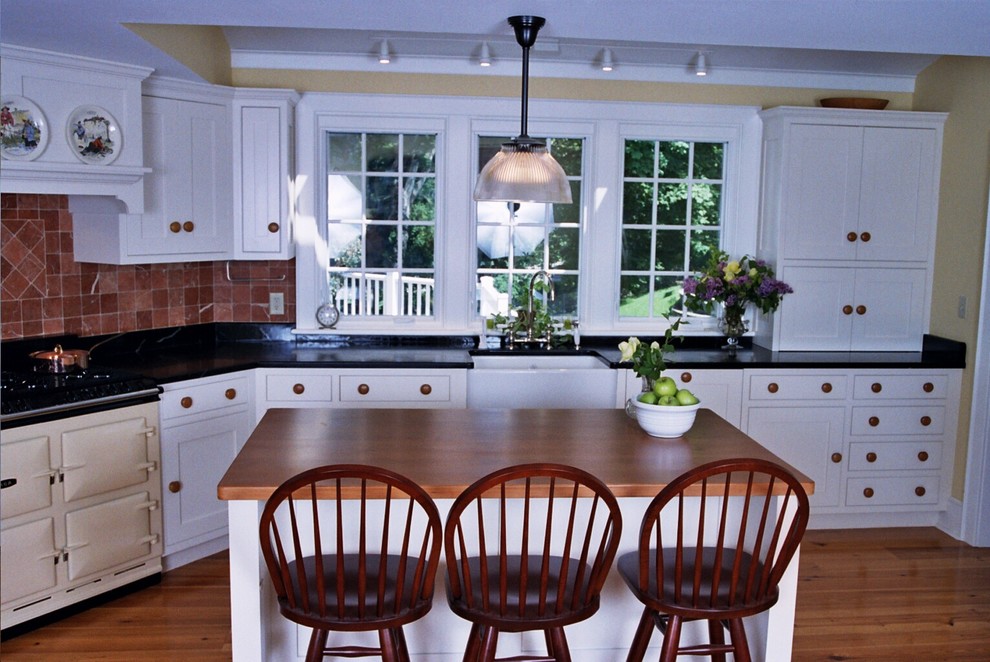Geschlossene Klassische Küche in U-Form mit Landhausspüle, flächenbündigen Schrankfronten, weißen Schränken, Küchenrückwand in Rot, Rückwand aus Keramikfliesen, bunten Elektrogeräten, hellem Holzboden und Kücheninsel in Boston