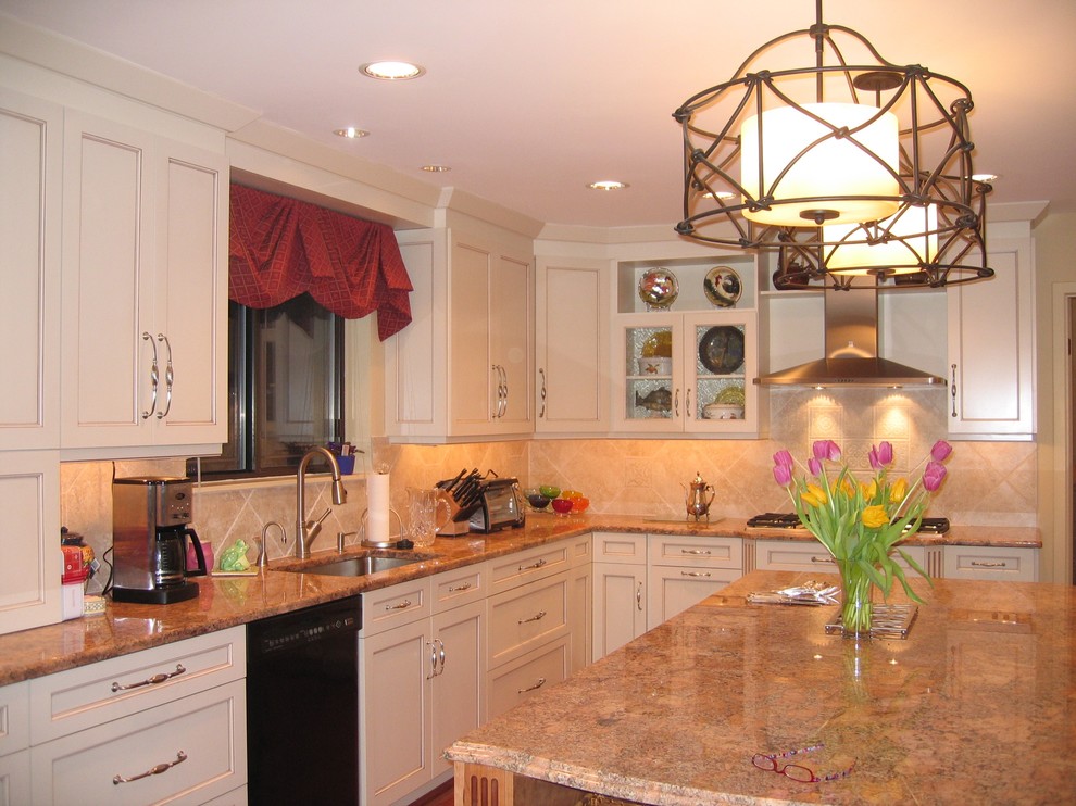Esempio di una cucina chic di medie dimensioni con lavello sottopiano, ante a filo, ante bianche, top in granito, paraspruzzi beige, paraspruzzi con piastrelle in ceramica, elettrodomestici neri e pavimento marrone