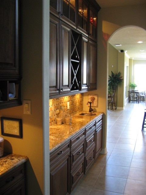 Cottage beige floor kitchen photo in Houston with raised-panel cabinets, dark wood cabinets and granite countertops