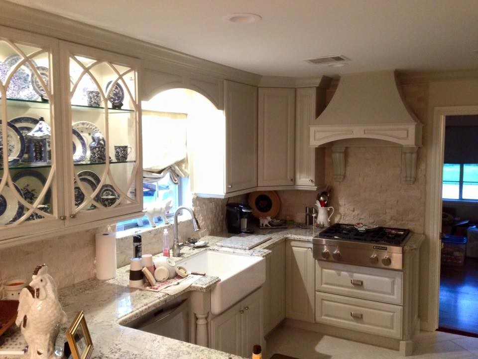 Example of a small country u-shaped kitchen design in Houston with a farmhouse sink, raised-panel cabinets, white cabinets, granite countertops, beige backsplash and stainless steel appliances