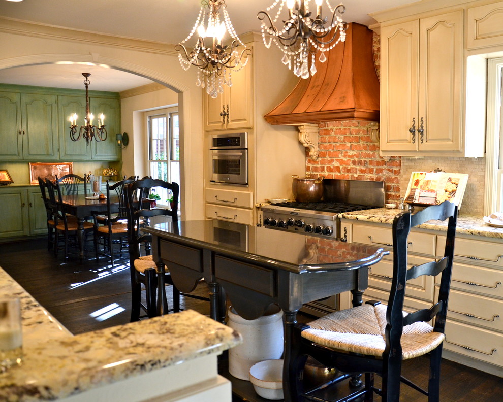 Eat-in kitchen - large traditional u-shaped dark wood floor and brown floor eat-in kitchen idea in Austin with granite countertops, stainless steel appliances, a farmhouse sink, shaker cabinets, beige cabinets, white backsplash, glass tile backsplash and an island