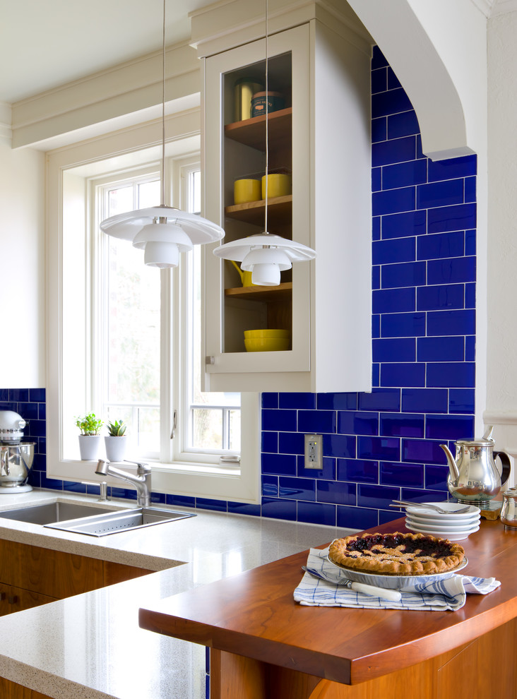 Inspiration for a transitional kitchen remodel in Toronto with a double-bowl sink, glass-front cabinets, white cabinets, blue backsplash, subway tile backsplash and a peninsula