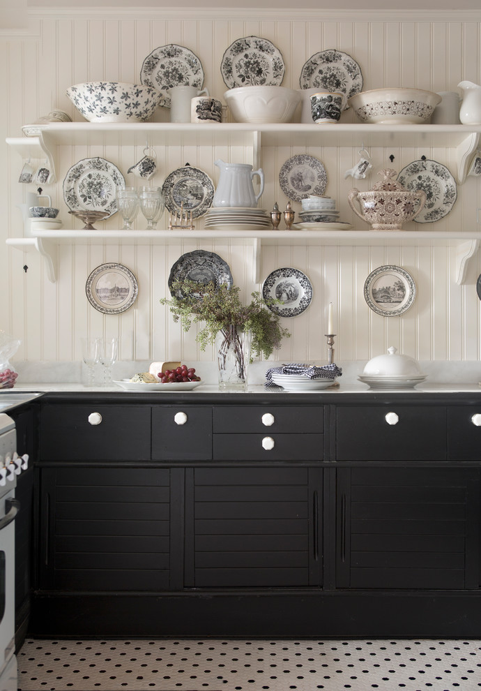 ニューヨークにあるカントリー風のおしゃれなキッチン (黒いキャビネット、白い調理設備、白い床) の写真