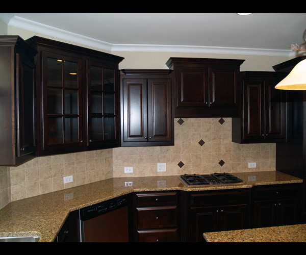 Foto på ett mellanstort funkis kök, med en dubbel diskho, luckor med glaspanel, skåp i mörkt trä, granitbänkskiva, flerfärgad stänkskydd, stänkskydd i stickkakel, rostfria vitvaror och en köksö