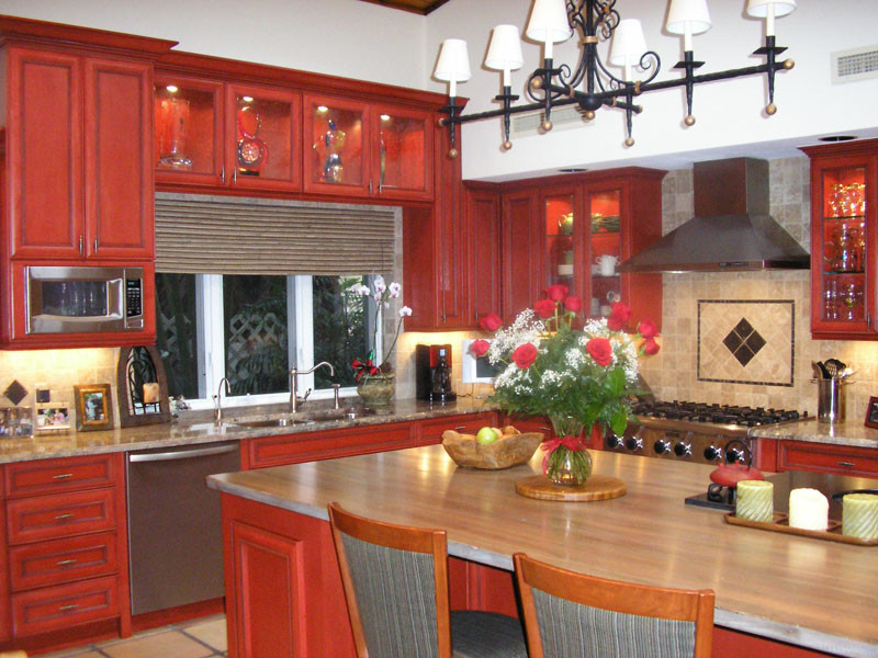 Mittelgroße Mediterrane Wohnküche in L-Form mit Doppelwaschbecken, Glasfronten, roten Schränken, Arbeitsplatte aus Holz, bunter Rückwand, Rückwand aus Mosaikfliesen, Küchengeräten aus Edelstahl, Keramikboden und Kücheninsel in Miami