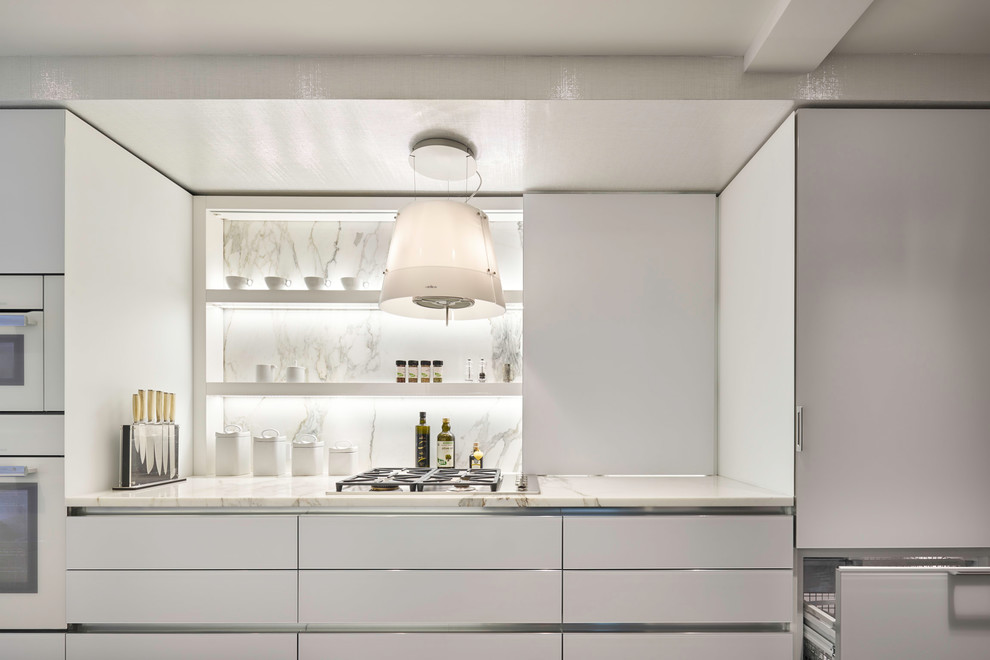 Imagen de cocina moderna con armarios con paneles lisos, puertas de armario blancas, encimera de mármol, salpicadero de mármol y electrodomésticos con paneles