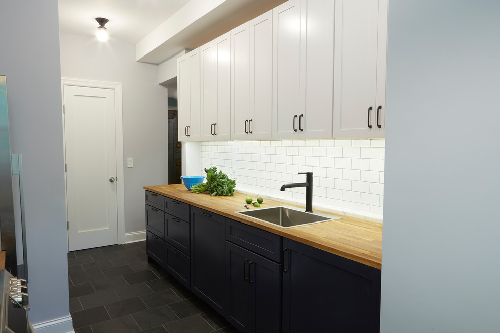 Esempio di una cucina parallela tradizionale con ante in stile shaker, paraspruzzi bianco, paraspruzzi con piastrelle in ceramica, pavimento con piastrelle in ceramica, pavimento nero e top in legno