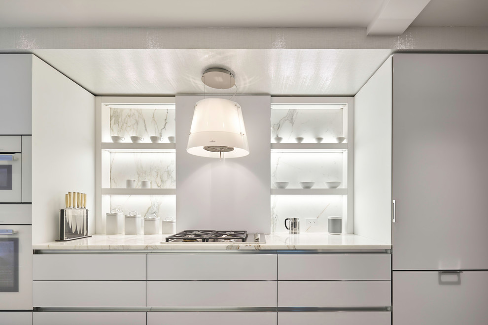 Diseño de cocina moderna con armarios con paneles lisos, puertas de armario blancas, encimera de mármol, salpicadero de mármol y electrodomésticos con paneles