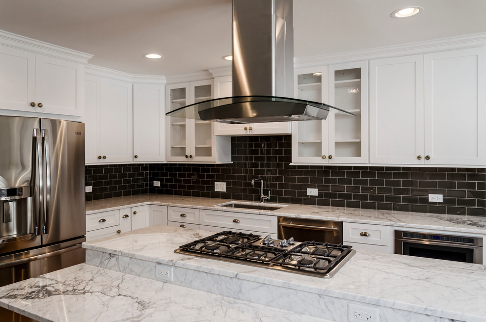 This is an example of a medium sized contemporary l-shaped kitchen/diner in Chicago with a submerged sink, recessed-panel cabinets, white cabinets, granite worktops, grey splashback, metro tiled splashback, stainless steel appliances and medium hardwood flooring.