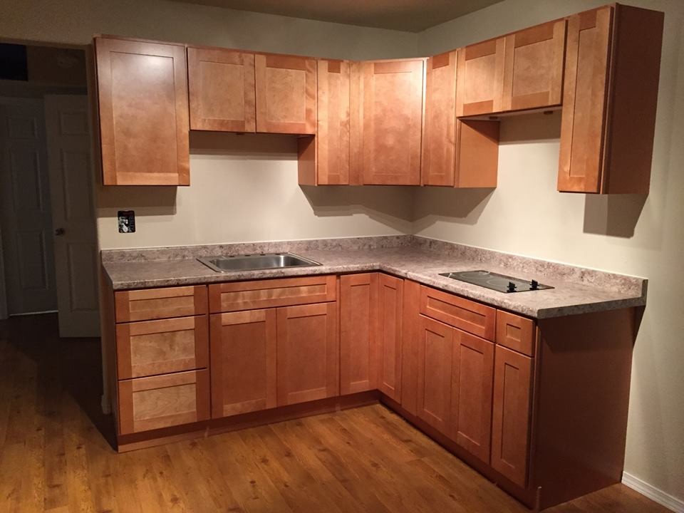 Kleine Klassische Küche in L-Form mit Einbauwaschbecken, Schrankfronten im Shaker-Stil, hellen Holzschränken und hellem Holzboden in Sonstige