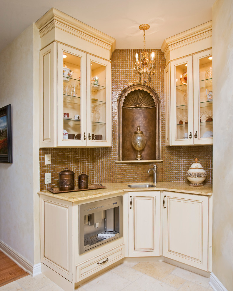 Eat-in kitchen - large victorian u-shaped travertine floor and beige floor eat-in kitchen idea in New York with a drop-in sink, raised-panel cabinets, beige cabinets, granite countertops, beige backsplash, stone tile backsplash, stainless steel appliances and an island