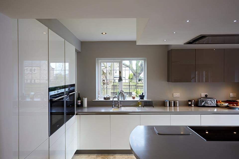 This is an example of a medium sized contemporary u-shaped open plan kitchen in Kent with a built-in sink, laminate countertops, coloured appliances, ceramic flooring and an island.