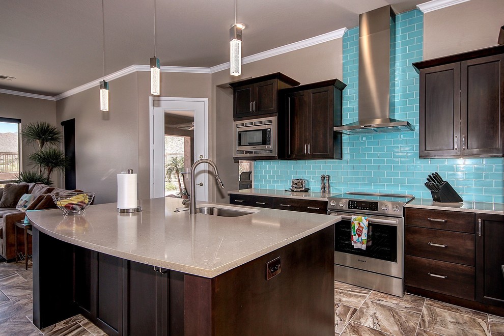 Example of a mid-sized trendy l-shaped beige floor eat-in kitchen design in Phoenix with an undermount sink, flat-panel cabinets, dark wood cabinets, quartz countertops, blue backsplash, glass tile backsplash, stainless steel appliances, an island and gray countertops