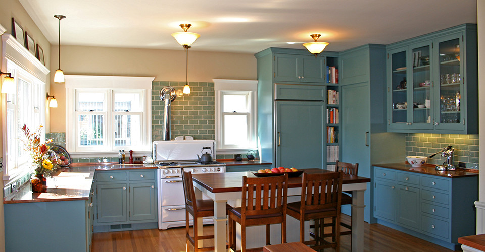 Exempel på ett stort lantligt kök, med en undermonterad diskho, luckor med infälld panel, blå skåp, bänkskiva i akrylsten, blått stänkskydd, stänkskydd i glaskakel, vita vitvaror, mellanmörkt trägolv och en köksö