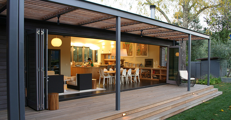 Exemple d'une petite cuisine ouverte moderne en L et bois clair avec un placard à porte vitrée, un électroménager en acier inoxydable, parquet foncé et îlot.