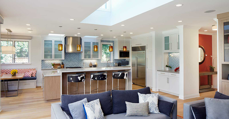 Bild på ett funkis kök, med en undermonterad diskho, luckor med glaspanel, vita skåp, bänkskiva i kvarts, blått stänkskydd, stänkskydd i porslinskakel, rostfria vitvaror, ljust trägolv och en köksö