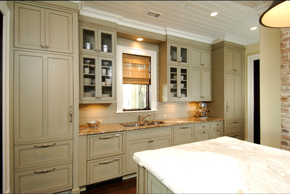 This is an example of a large traditional u-shaped kitchen/diner in Charleston with a double-bowl sink, beaded cabinets, green cabinets, marble worktops, stainless steel appliances, dark hardwood flooring and an island.