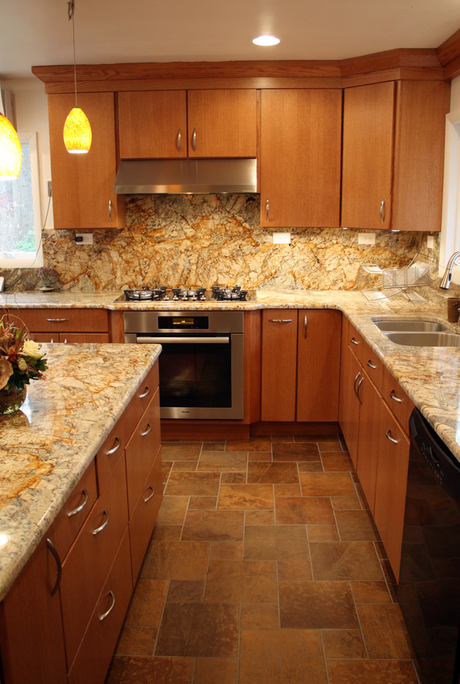 Modern inredning av ett kök, med en undermonterad diskho, släta luckor, skåp i mellenmörkt trä, granitbänkskiva, gult stänkskydd, stänkskydd i sten och integrerade vitvaror