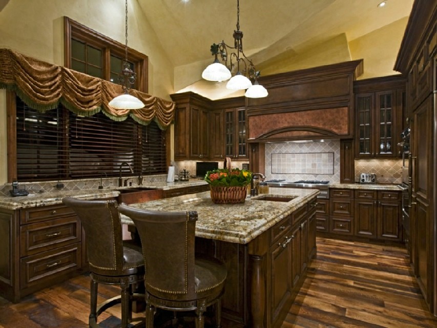 Kitchen - large traditional dark wood floor kitchen idea in Denver with a drop-in sink, raised-panel cabinets, medium tone wood cabinets, granite countertops, stainless steel appliances and an island