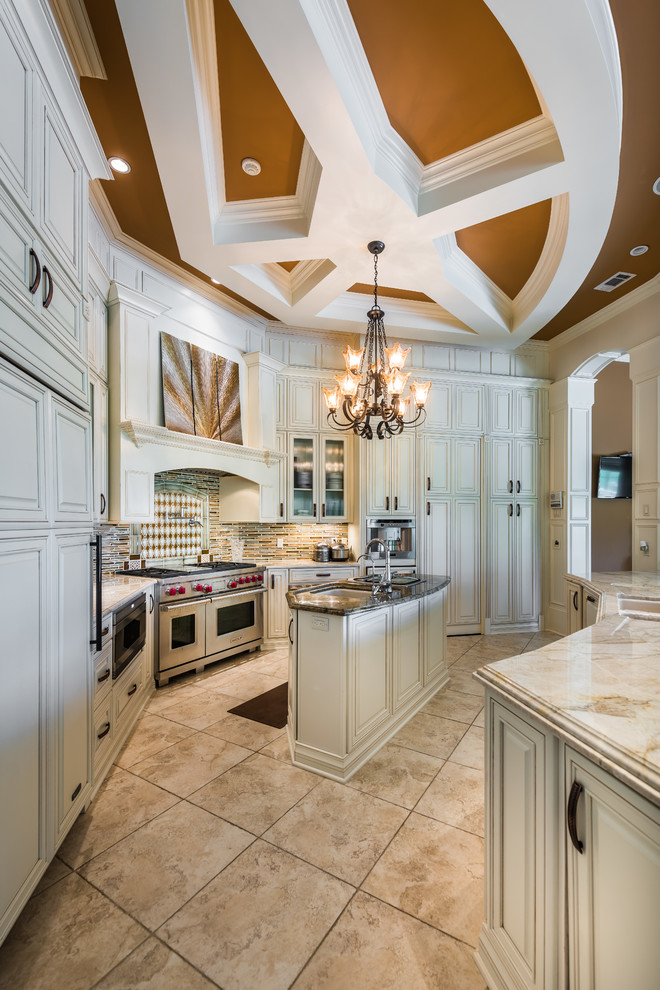 Inspiration for a large transitional l-shaped porcelain tile eat-in kitchen remodel in New Orleans with raised-panel cabinets, white cabinets, stainless steel appliances, an island, a double-bowl sink, glass countertops, multicolored backsplash and matchstick tile backsplash