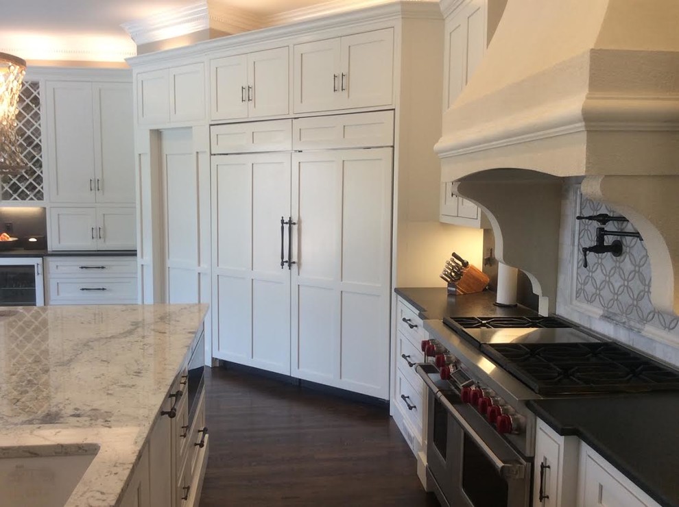 This is an example of a medium sized traditional u-shaped kitchen/diner in Atlanta with a submerged sink, recessed-panel cabinets, white cabinets, marble worktops, white splashback, marble splashback, stainless steel appliances, dark hardwood flooring, an island, brown floors and white worktops.