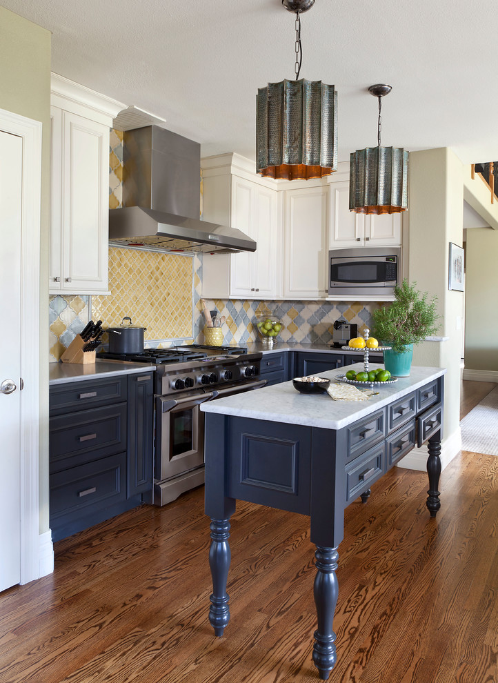 Kitchen - mid-sized traditional dark wood floor and brown floor kitchen idea in Denver with recessed-panel cabinets, multicolored backsplash, an island, blue cabinets, marble countertops, ceramic backsplash and stainless steel appliances