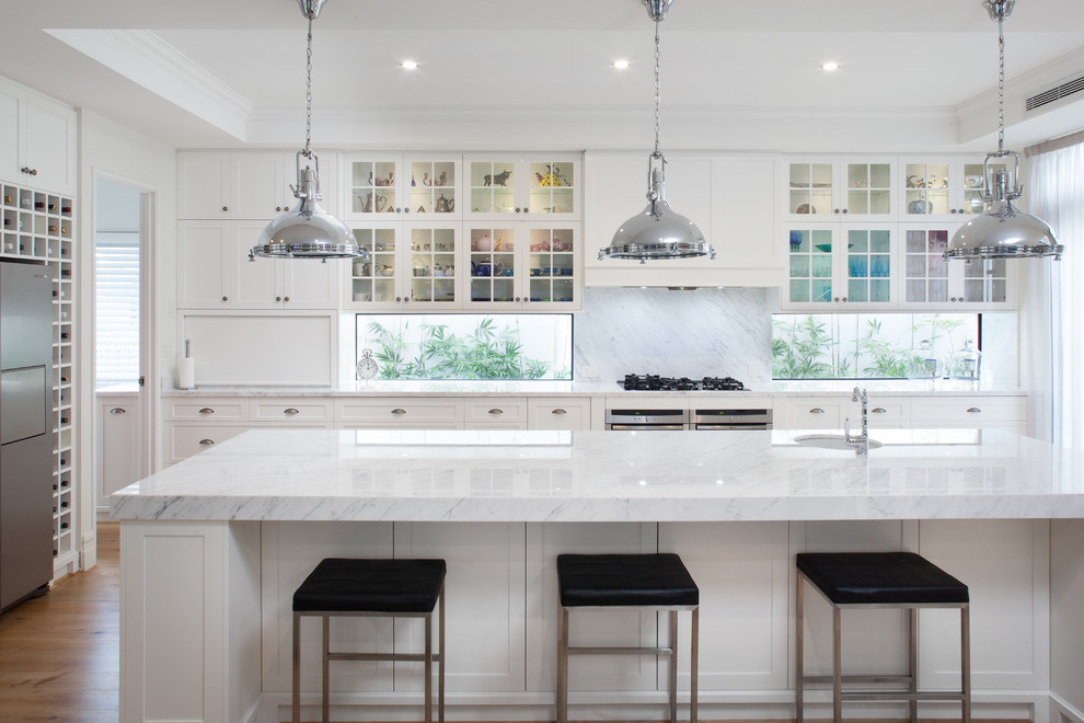 Klassische Küche in L-Form mit Unterbauwaschbecken, Glasfronten, weißen Schränken, Rückwand-Fenster, Küchengeräten aus Edelstahl, braunem Holzboden, Kücheninsel und braunem Boden in Perth