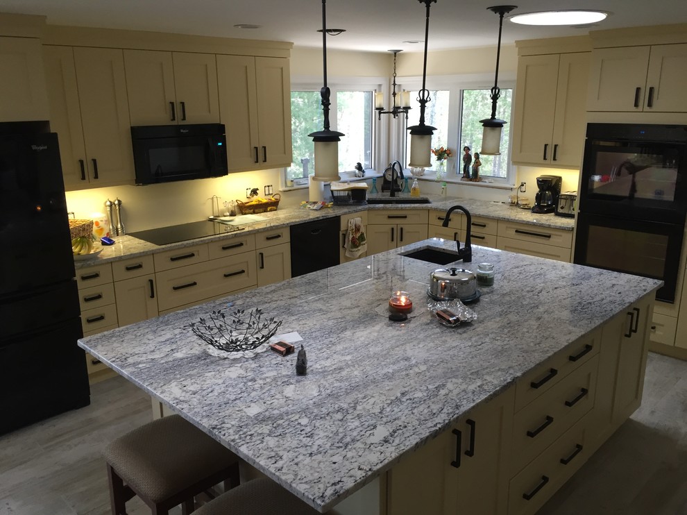 Foto di una cucina chic di medie dimensioni con lavello a vasca singola, ante in stile shaker, ante bianche, top in granito, elettrodomestici neri, pavimento in laminato e pavimento verde