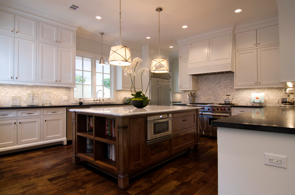 Example of a large classic u-shaped medium tone wood floor eat-in kitchen design in Houston with an undermount sink, shaker cabinets, white cabinets, granite countertops, gray backsplash, ceramic backsplash, stainless steel appliances and an island