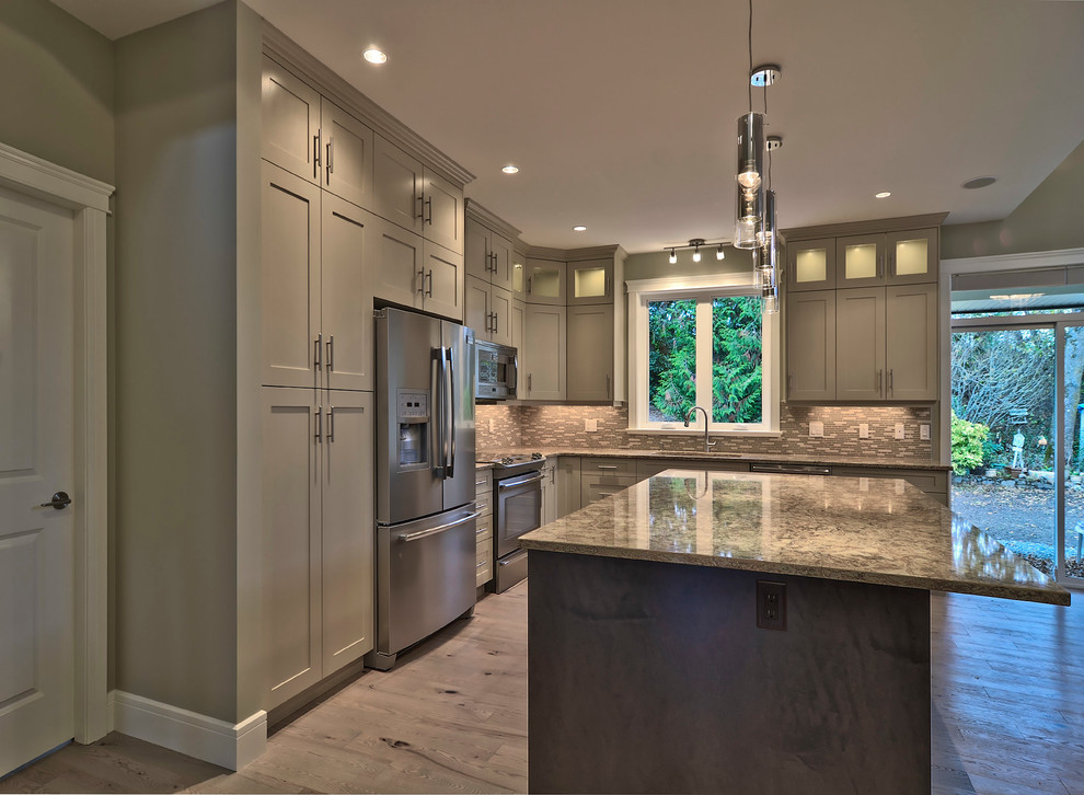 Inspiration for a timeless l-shaped eat-in kitchen remodel in Vancouver with an undermount sink, shaker cabinets, gray cabinets, granite countertops, brown backsplash and stainless steel appliances