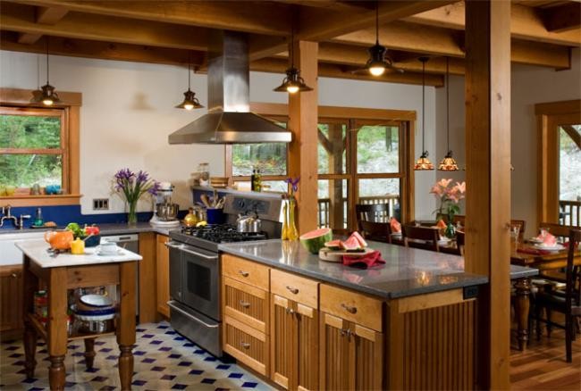 Inredning av ett lantligt mellanstort kök, med en rustik diskho, luckor med lamellpanel, skåp i ljust trä, rostfria vitvaror och en köksö