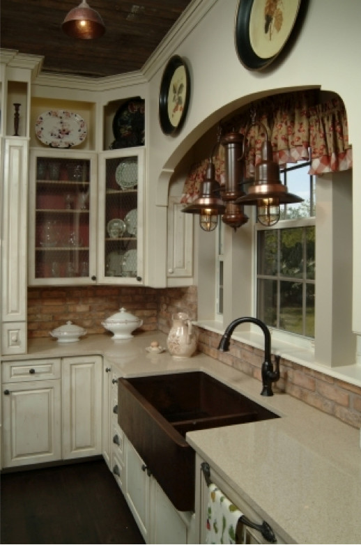 Exempel på ett mellanstort lantligt kök, med mörkt trägolv, luckor med upphöjd panel, skåp i slitet trä, bänkskiva i kvartsit, brunt stänkskydd, en köksö, en rustik diskho och integrerade vitvaror
