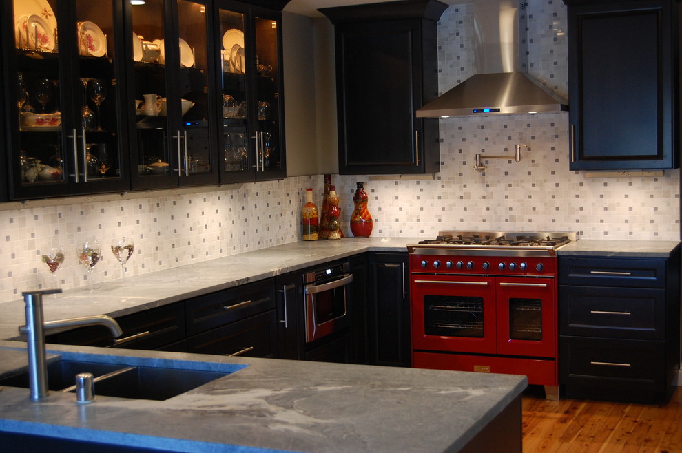 Idéer för ett mellanstort modernt u-kök, med en undermonterad diskho, luckor med infälld panel, svarta skåp, marmorbänkskiva, grått stänkskydd, stänkskydd i stenkakel, färgglada vitvaror, mellanmörkt trägolv, en halv köksö och brunt golv