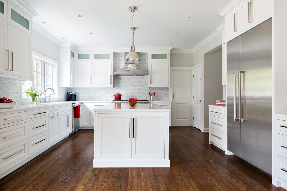 Inspiration for an u-shaped dark wood floor kitchen remodel in New York with an undermount sink, shaker cabinets, white cabinets, gray backsplash, subway tile backsplash, stainless steel appliances and an island