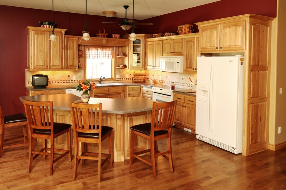 Example of a mid-sized classic l-shaped medium tone wood floor and brown floor open concept kitchen design in Wichita with a double-bowl sink, raised-panel cabinets, light wood cabinets, laminate countertops, beige backsplash, ceramic backsplash, white appliances, an island and brown countertops
