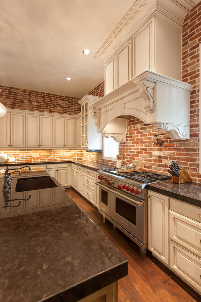 Bild på ett stort vintage kök, med en rustik diskho, luckor med upphöjd panel, vita skåp, granitbänkskiva, flerfärgad stänkskydd, stänkskydd i terrakottakakel, integrerade vitvaror, mellanmörkt trägolv och en köksö