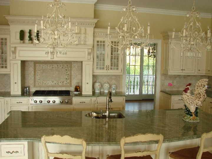 Foto på ett stort vintage kök, med luckor med upphöjd panel, vita skåp, granitbänkskiva, beige stänkskydd, stänkskydd i keramik, rostfria vitvaror, mellanmörkt trägolv och en köksö