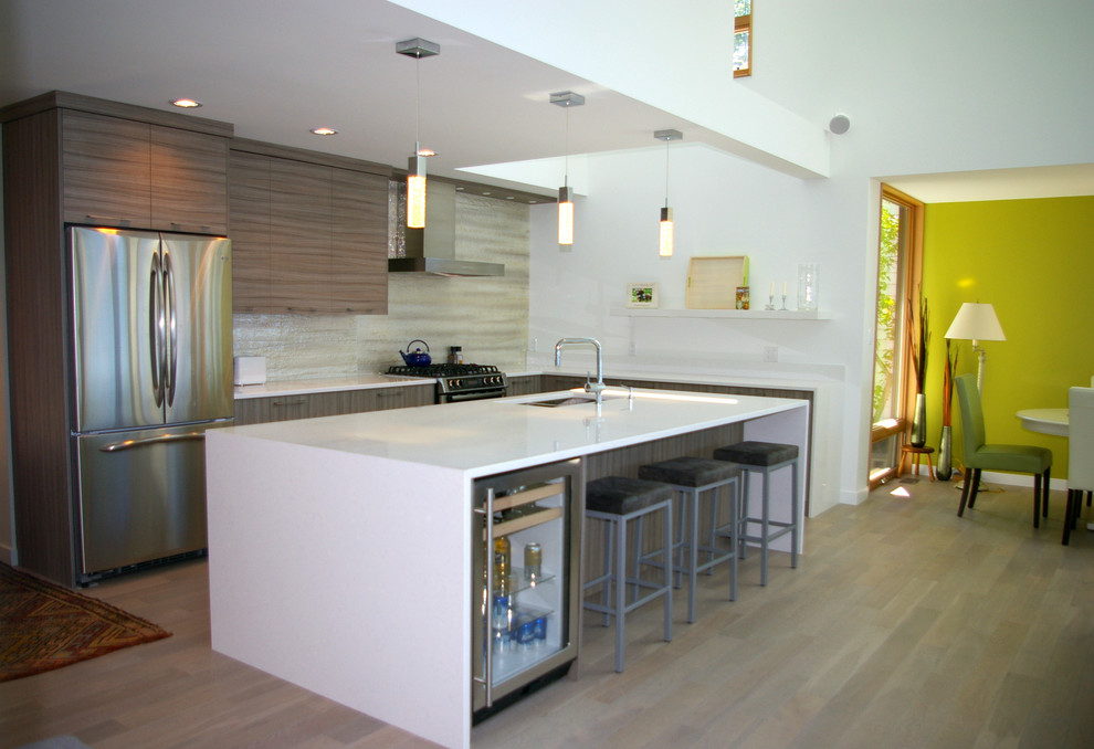 Design ideas for a small contemporary l-shaped open plan kitchen in Vancouver with a submerged sink, flat-panel cabinets, beige cabinets, composite countertops, glass sheet splashback, stainless steel appliances, beige splashback, light hardwood flooring and an island.