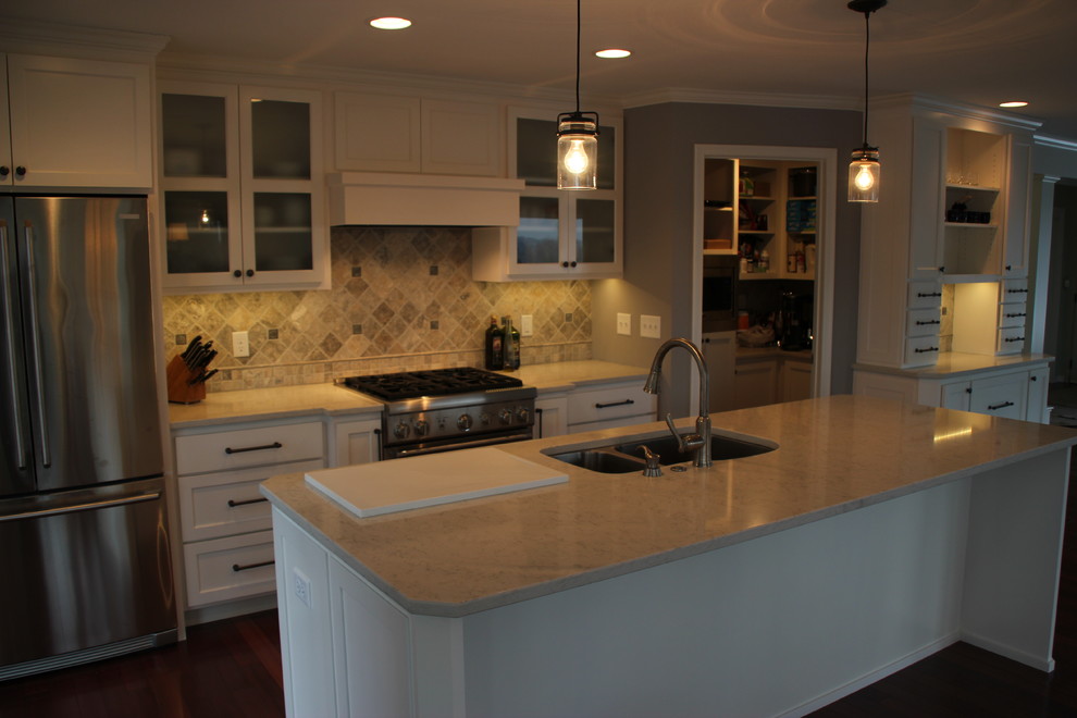 Photo of a small classic galley kitchen/diner in Minneapolis with an island, a submerged sink, shaker cabinets, white cabinets, grey splashback, stone tiled splashback, white appliances and dark hardwood flooring.