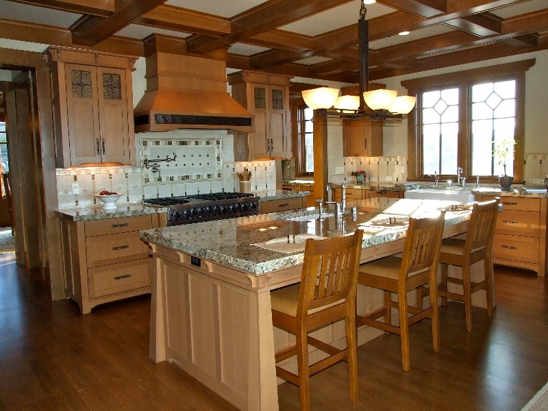 Cette photo montre une grande cuisine américaine montagne en bois foncé avec un plan de travail en granite, un électroménager en acier inoxydable, un sol en bois brun et îlot.