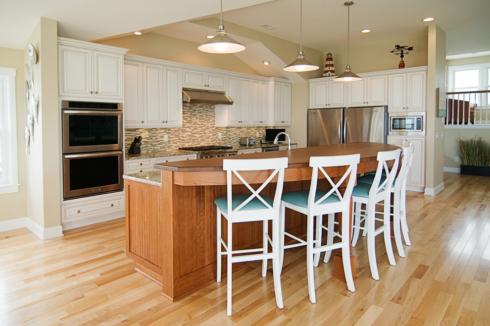 Example of a classic kitchen design in Other with raised-panel cabinets, white cabinets, multicolored backsplash and stainless steel appliances