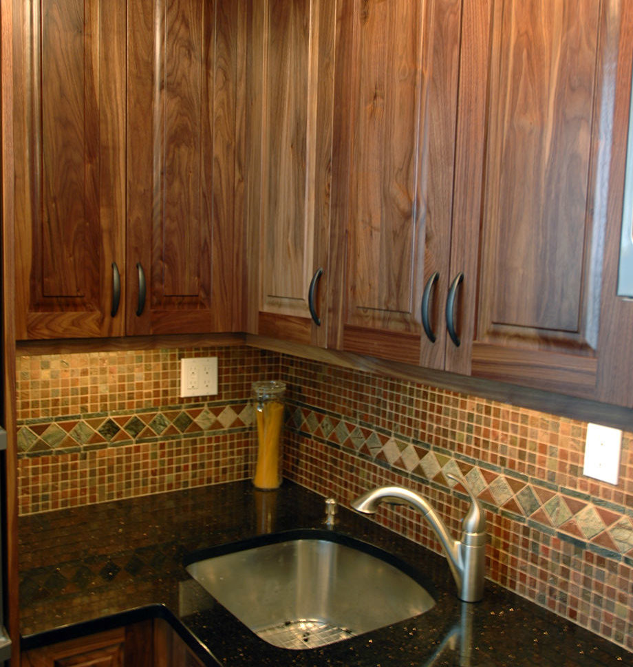 Exempel på ett avskilt, mellanstort amerikanskt linjärt kök, med luckor med upphöjd panel, vita skåp och marmorbänkskiva