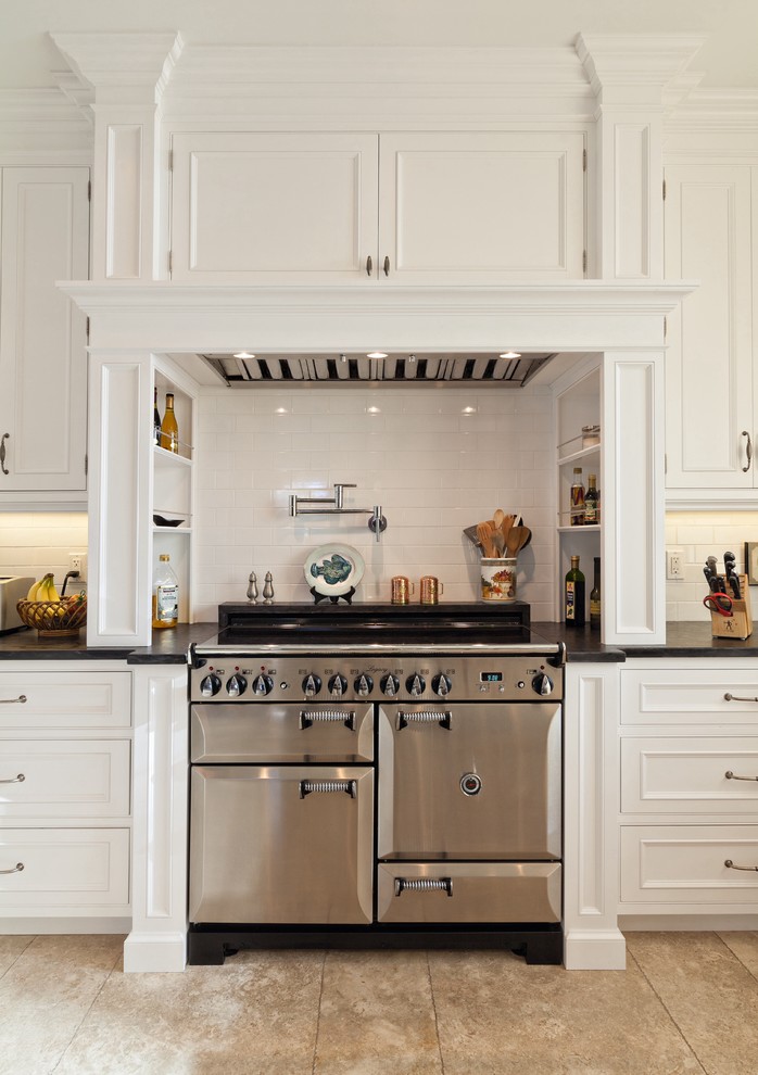 This is an example of a traditional kitchen in Miami with metro tiled splashback, stainless steel appliances, white splashback, white cabinets and beaded cabinets.