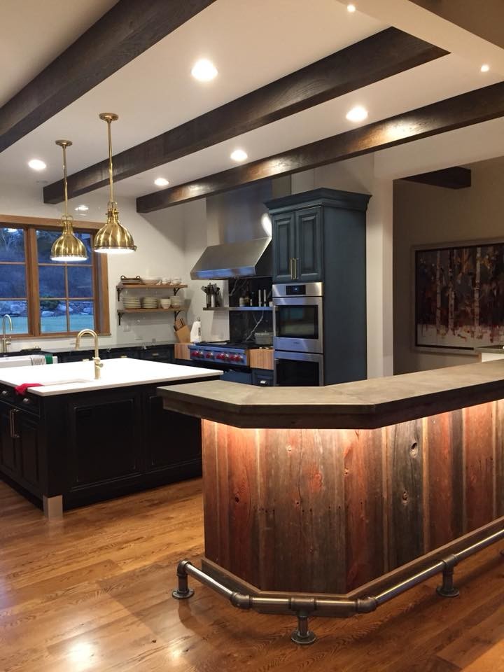 Lantlig inredning av ett mellanstort vit vitt kök, med en rustik diskho, luckor med upphöjd panel, blå skåp, bänkskiva i akrylsten, rostfria vitvaror, mellanmörkt trägolv, flera köksöar och brunt golv