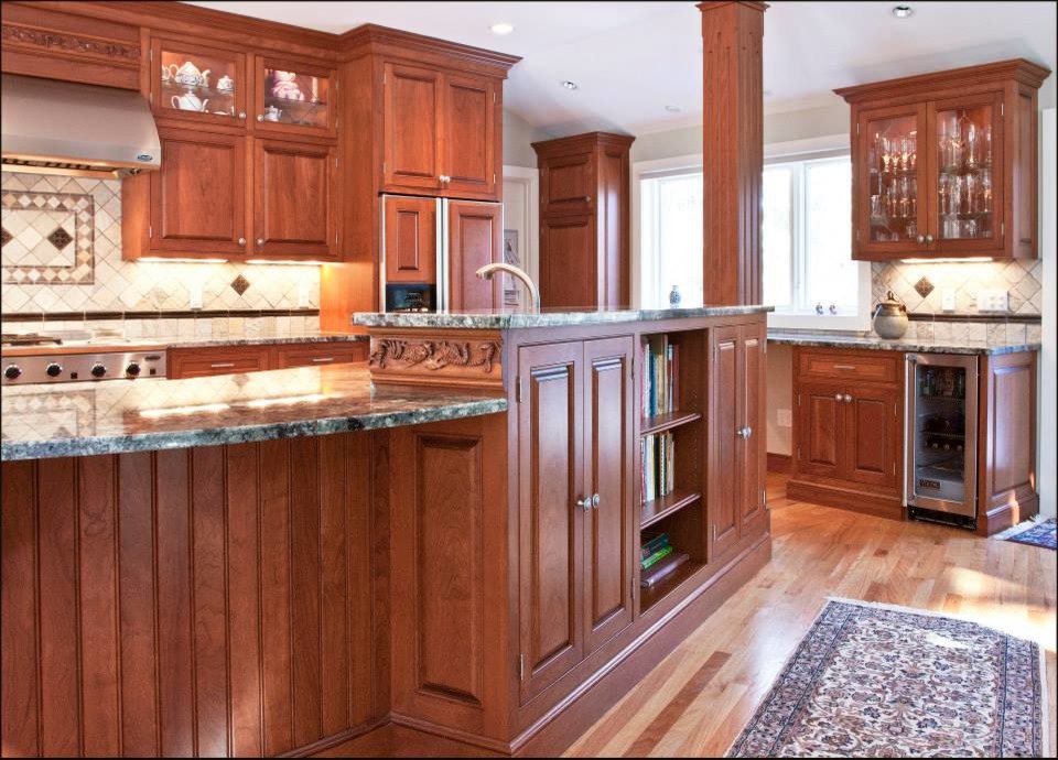 Photo of a large traditional l-shaped kitchen/diner in Boston with raised-panel cabinets, medium wood cabinets, granite worktops, an island, a submerged sink, white splashback, ceramic splashback, stainless steel appliances and light hardwood flooring.