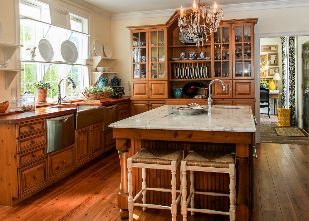 Geschlossene Klassische Küche mit Landhausspüle, Glasfronten, hellbraunen Holzschränken, Arbeitsplatte aus Holz, Küchengeräten aus Edelstahl, braunem Holzboden und Kücheninsel in Boston