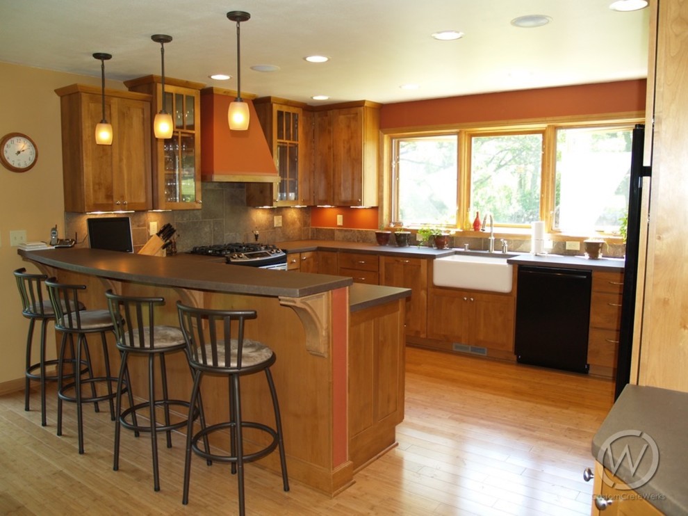 Example of a mid-sized classic u-shaped medium tone wood floor eat-in kitchen design in Milwaukee with an undermount sink, shaker cabinets, medium tone wood cabinets, concrete countertops and no island