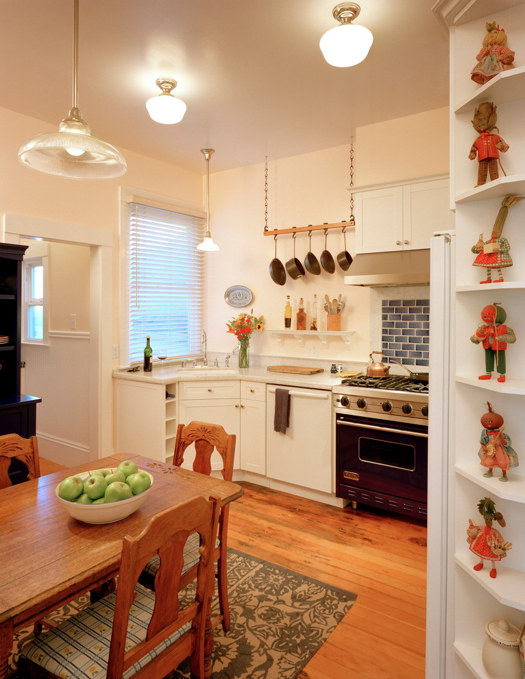 Modelo de cocina bohemia con armarios con paneles empotrados, puertas de armario blancas, encimera de mármol, salpicadero con mosaicos de azulejos y electrodomésticos de colores