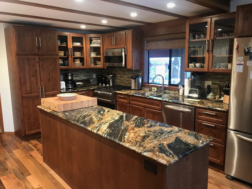 Medium sized traditional l-shaped kitchen in Sacramento with a double-bowl sink, recessed-panel cabinets, dark wood cabinets, granite worktops, matchstick tiled splashback, stainless steel appliances, medium hardwood flooring, an island, brown floors and multicoloured worktops.